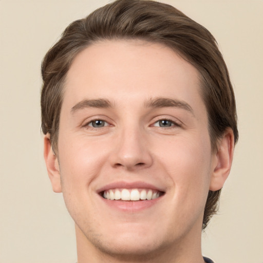 Joyful white young-adult male with short  brown hair and green eyes