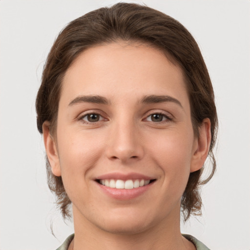 Joyful white young-adult female with medium  brown hair and brown eyes