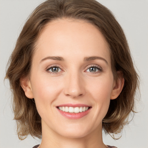 Joyful white young-adult female with medium  brown hair and green eyes