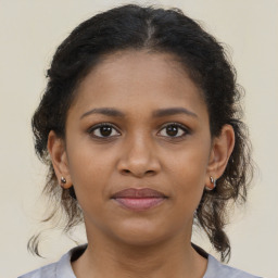 Joyful black young-adult female with medium  brown hair and brown eyes