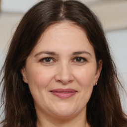 Joyful white adult female with long  brown hair and brown eyes