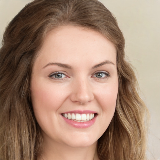 Joyful white young-adult female with long  brown hair and green eyes