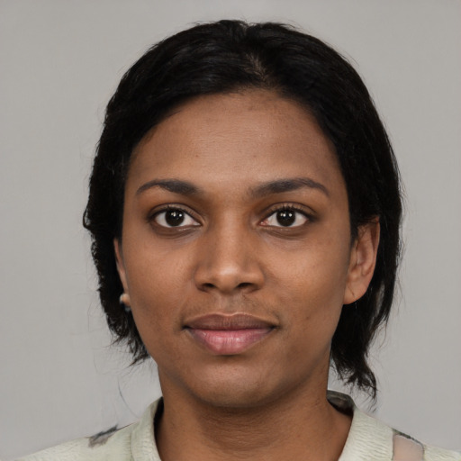 Joyful black young-adult female with medium  black hair and brown eyes