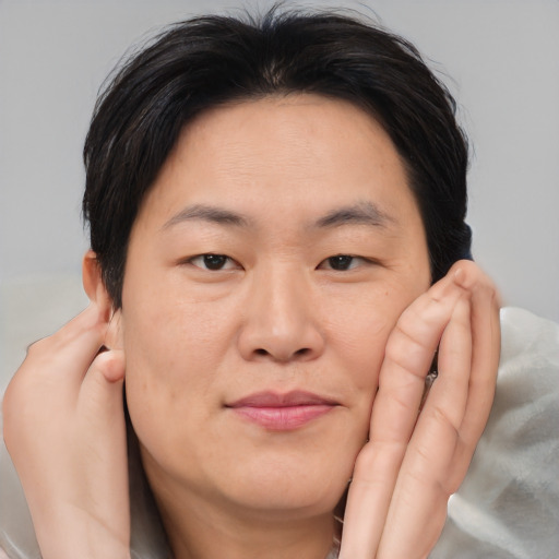 Joyful asian adult female with medium  brown hair and brown eyes