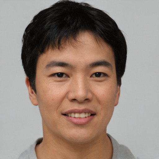 Joyful asian young-adult male with short  brown hair and brown eyes