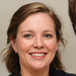 Joyful white adult female with medium  brown hair and blue eyes