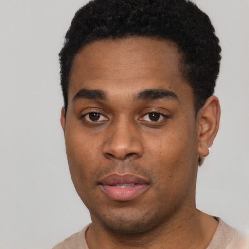 Joyful black young-adult male with short  black hair and brown eyes