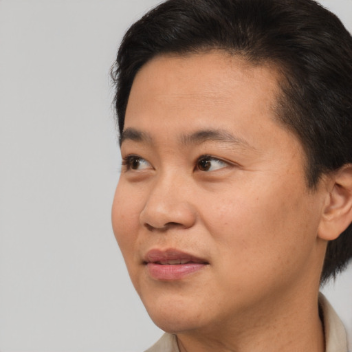 Joyful asian young-adult male with short  brown hair and brown eyes