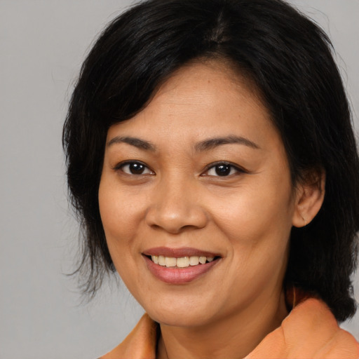 Joyful asian adult female with medium  brown hair and brown eyes