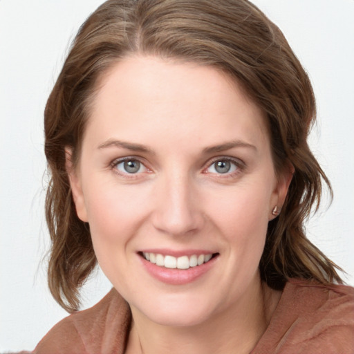 Joyful white young-adult female with medium  brown hair and blue eyes