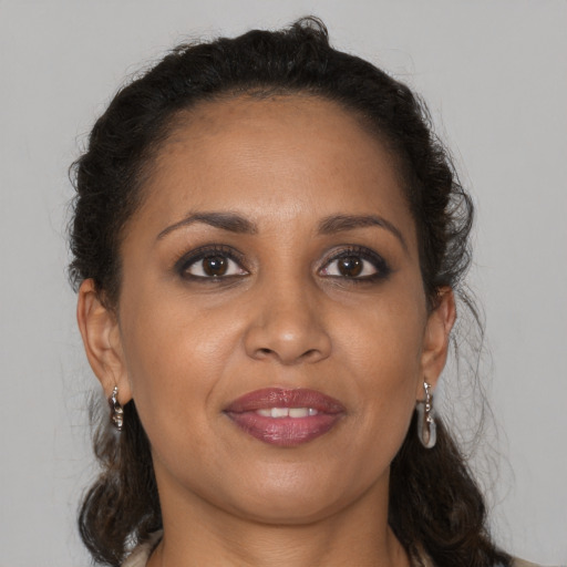 Joyful black adult female with long  brown hair and brown eyes