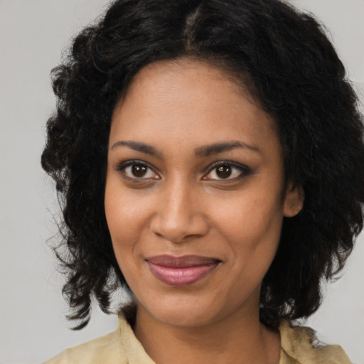 Joyful black young-adult female with medium  black hair and brown eyes