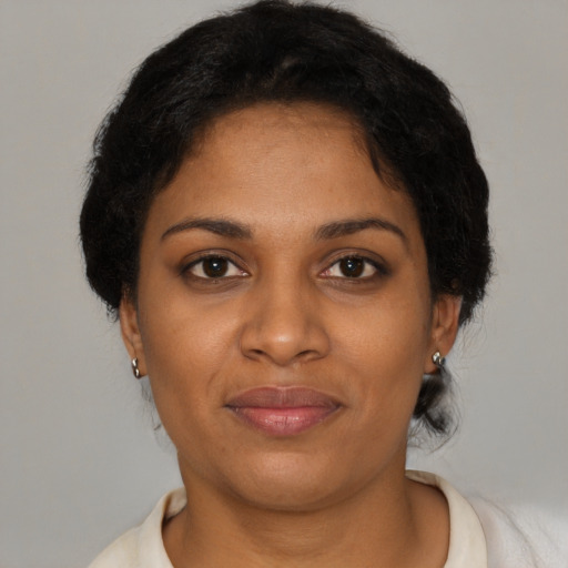 Joyful black young-adult female with short  brown hair and brown eyes