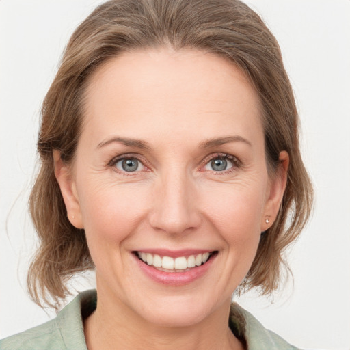 Joyful white adult female with medium  brown hair and grey eyes