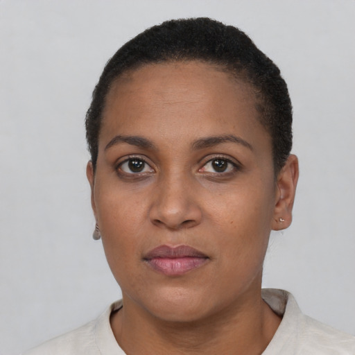 Joyful black young-adult female with short  black hair and brown eyes
