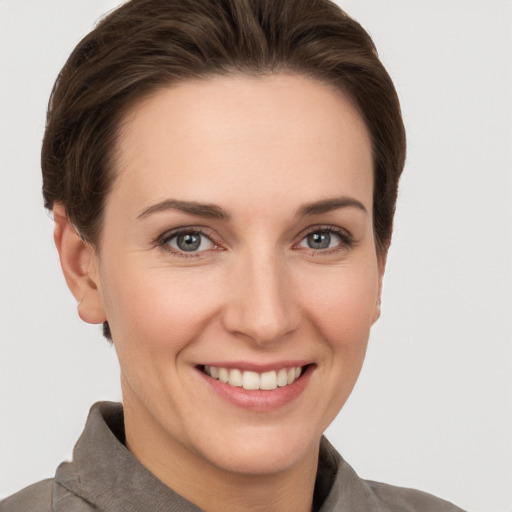 Joyful white young-adult female with short  brown hair and grey eyes