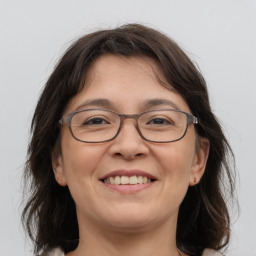 Joyful white adult female with medium  brown hair and grey eyes