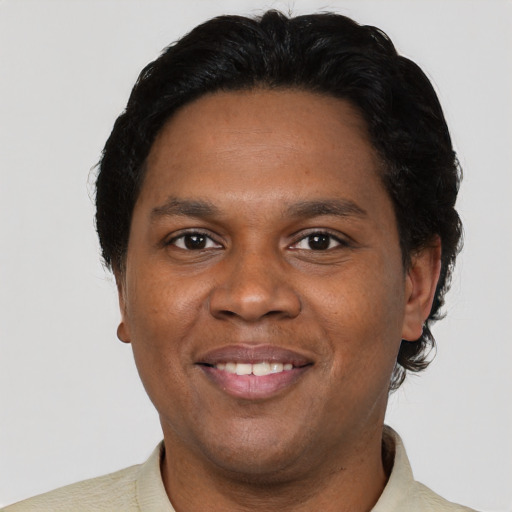 Joyful black young-adult male with short  brown hair and brown eyes