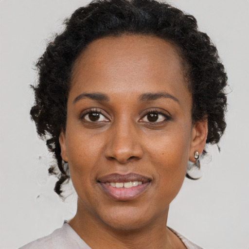 Joyful black adult female with short  brown hair and brown eyes