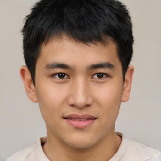 Joyful asian young-adult male with short  brown hair and brown eyes