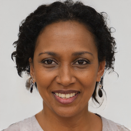 Joyful black adult female with short  brown hair and brown eyes