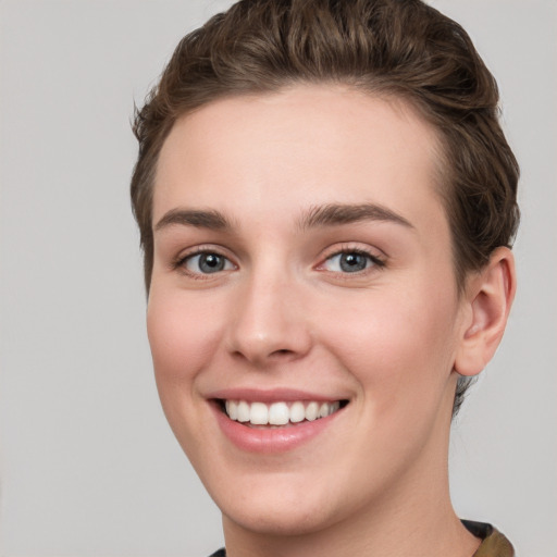 Joyful white young-adult female with short  brown hair and grey eyes