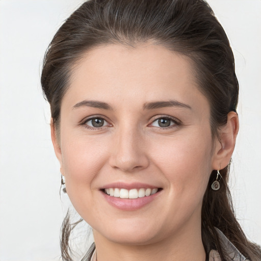 Joyful white young-adult female with long  brown hair and grey eyes