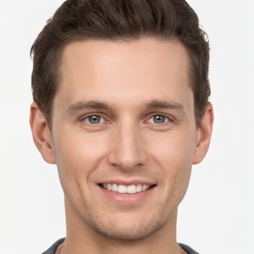 Joyful white young-adult male with short  brown hair and grey eyes