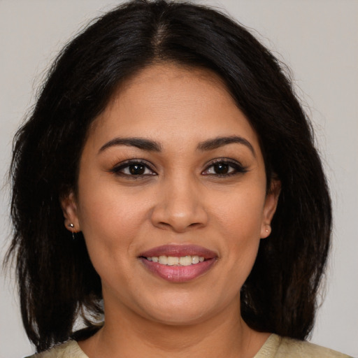 Joyful latino young-adult female with medium  brown hair and brown eyes