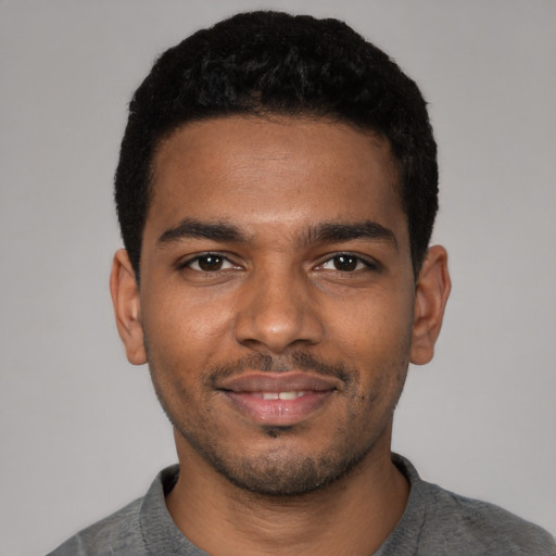 Joyful black young-adult male with short  black hair and brown eyes