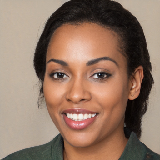 Joyful black young-adult female with long  black hair and brown eyes