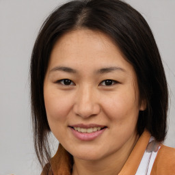 Joyful asian young-adult female with medium  brown hair and brown eyes