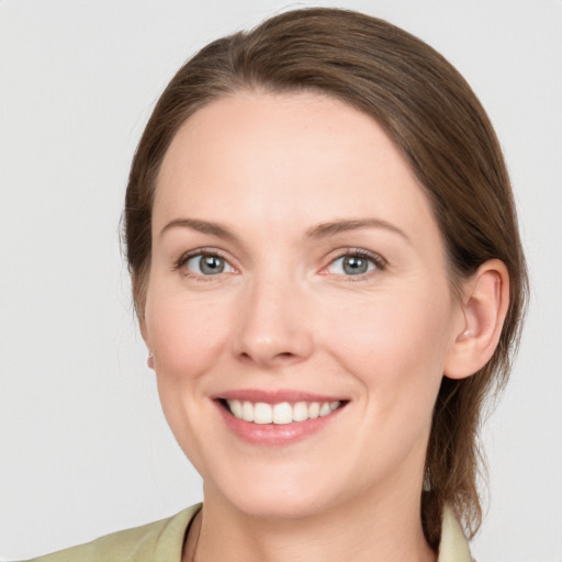 Joyful white young-adult female with medium  brown hair and grey eyes