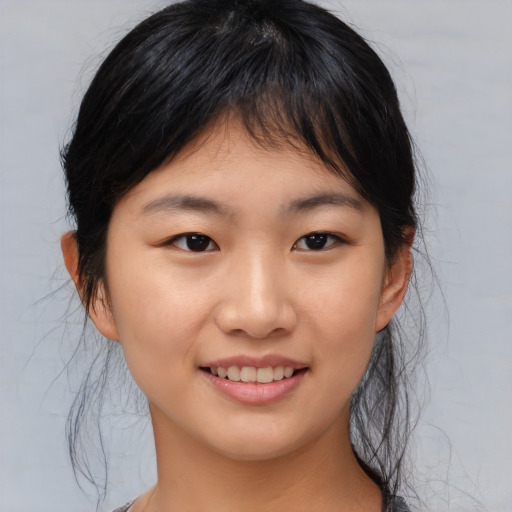 Joyful asian young-adult female with medium  brown hair and brown eyes