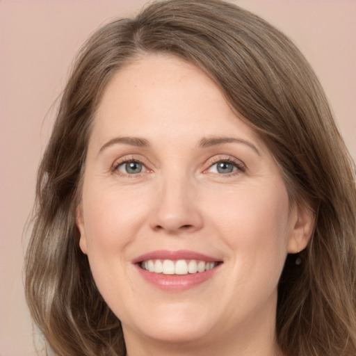 Joyful white adult female with medium  brown hair and grey eyes