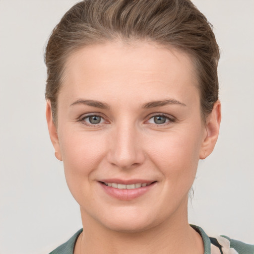 Joyful white young-adult female with short  brown hair and grey eyes