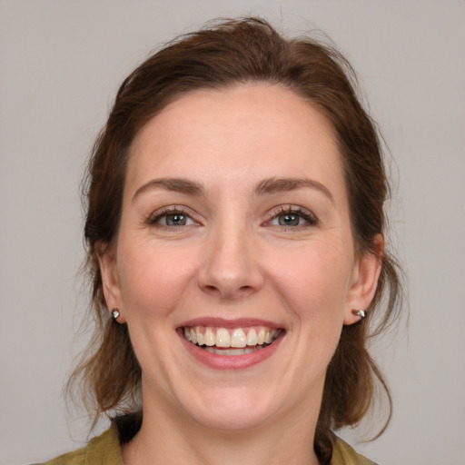 Joyful white young-adult female with medium  brown hair and blue eyes