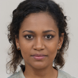 Joyful black young-adult female with long  brown hair and brown eyes