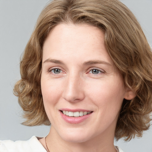 Joyful white young-adult female with medium  brown hair and blue eyes