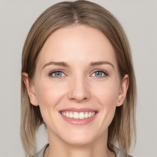 Joyful white young-adult female with medium  brown hair and grey eyes