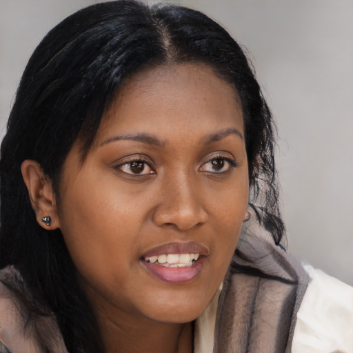 Joyful black young-adult female with long  brown hair and brown eyes