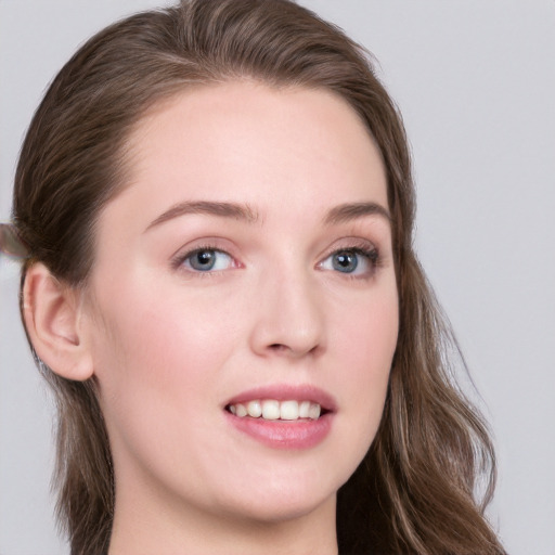 Joyful white young-adult female with long  brown hair and blue eyes