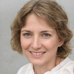 Joyful white adult female with medium  brown hair and grey eyes