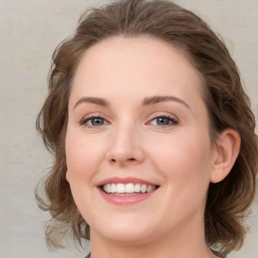 Joyful white young-adult female with medium  brown hair and green eyes