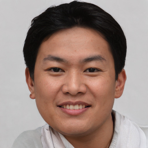 Joyful asian young-adult male with short  black hair and brown eyes