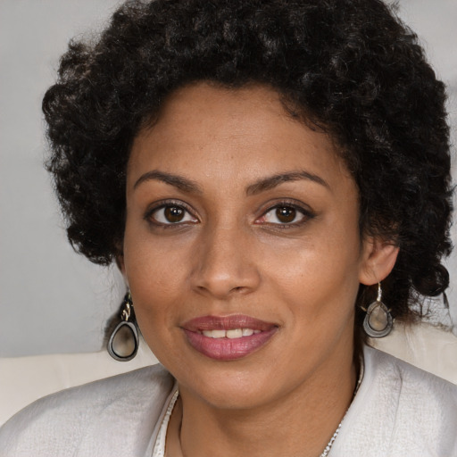 Joyful black young-adult female with long  brown hair and brown eyes