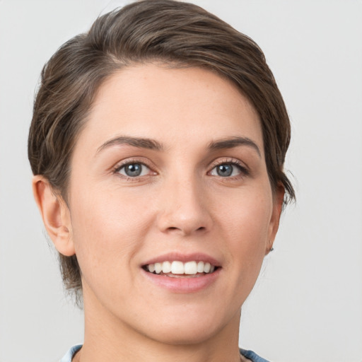 Joyful white young-adult female with short  brown hair and grey eyes