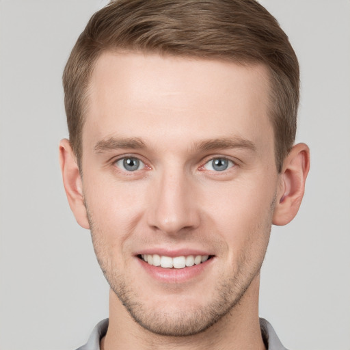 Joyful white young-adult male with short  brown hair and grey eyes