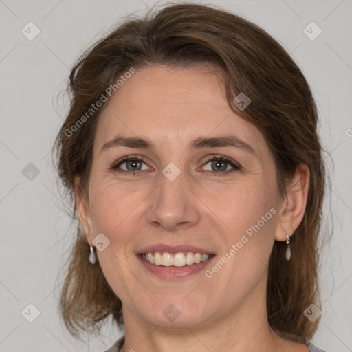 Joyful white adult female with medium  brown hair and grey eyes