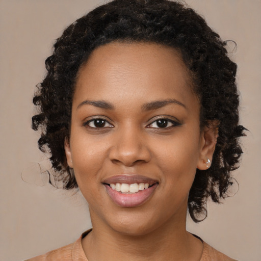 Joyful black young-adult female with medium  brown hair and brown eyes